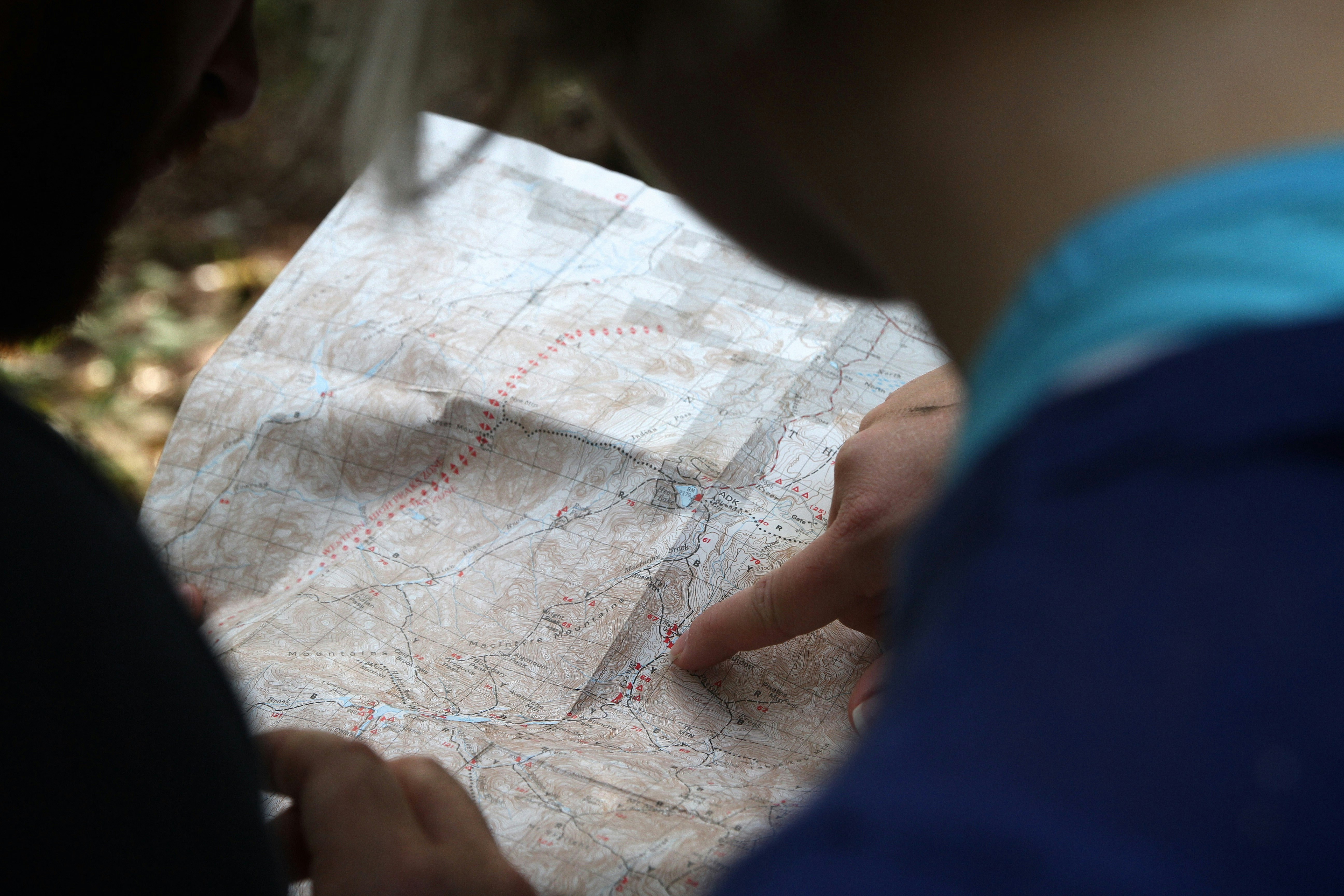 person pointing on beige map
